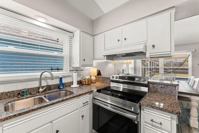 a kitchen with appliances a sink and cabinets