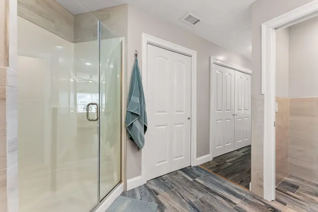 a bathroom with a shower and a glass door