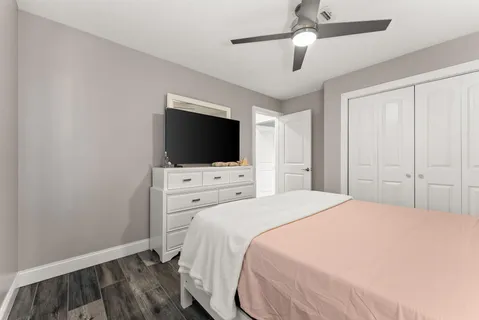a bedroom with a bed and a flat tv screen on dresser