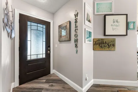 a view of a hallway with wooden floor and closet
