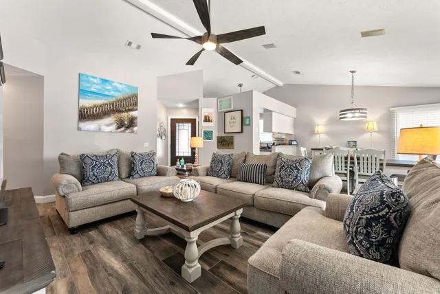 a living room with furniture a ceiling fan and a chandelier