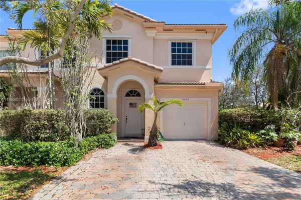 a view of a house with a yard and palm trees