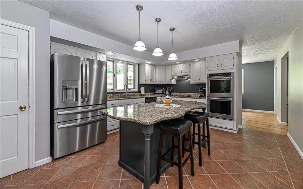 133 Miller Road Sarver, PA 16055 - Photo 7 of 50 a kitchen with stainless steel appliances granite countertop a sink a stove a dining table and chairs