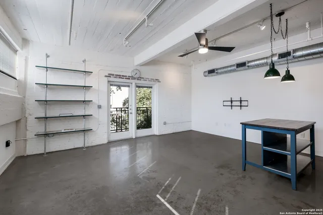 an empty room with a chandelier fan