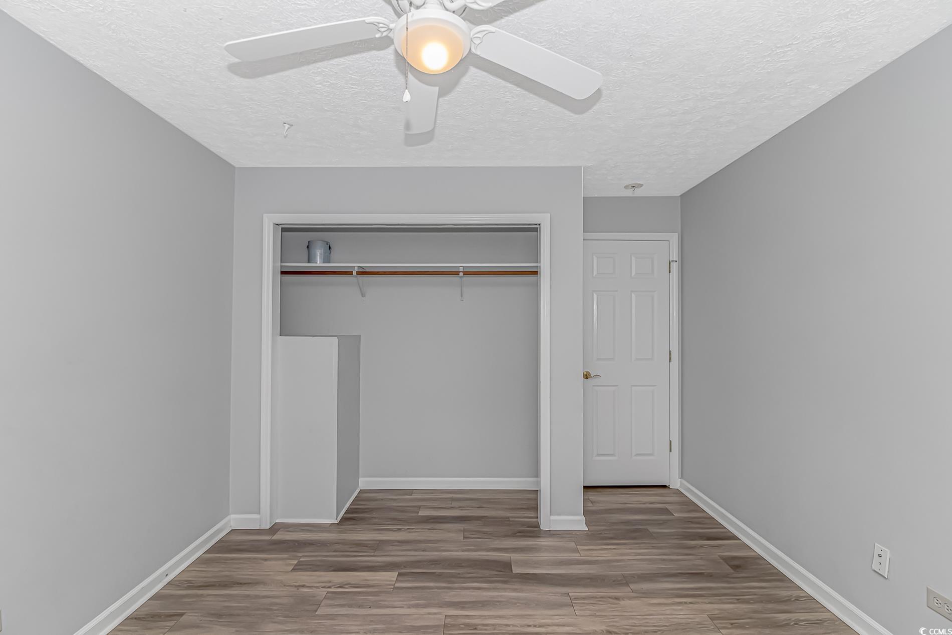 2829 Highway 129 Galivants Ferry, SC 29544 - Photo 12 of 40 Unfurnished bedroom featuring a textured ceiling, wood finished floors, a closet, and a ceiling fan