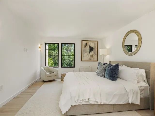 a bedroom with a bed and a large window