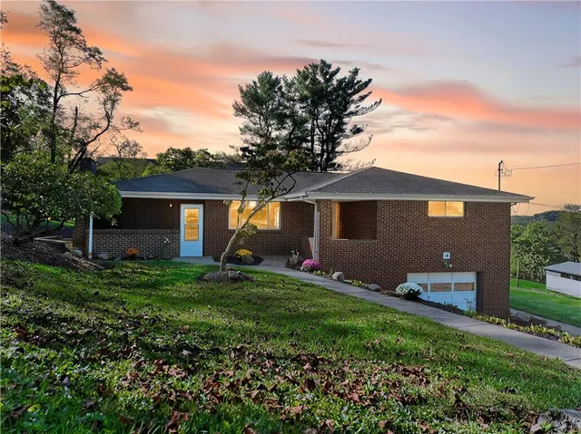 a view of a house with a yard and a garden