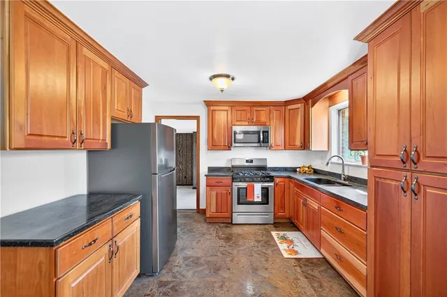 a kitchen with stainless steel appliances granite countertop a stove a sink dishwasher and a refrigerator