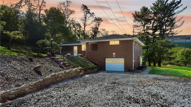 a view of a house with a yard and large trees