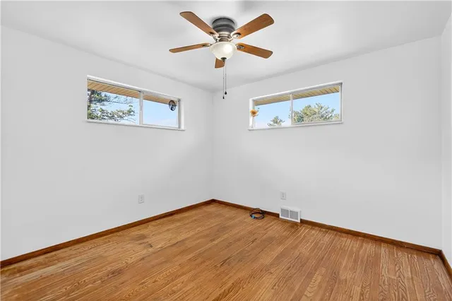 a view of a big room with wooden floor and a ceiling fan