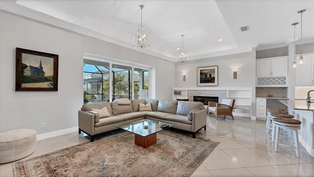 a living room with furniture a chandelier and a flat screen tv