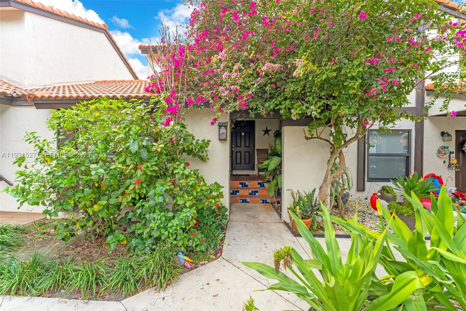 a front view of a house with a tree