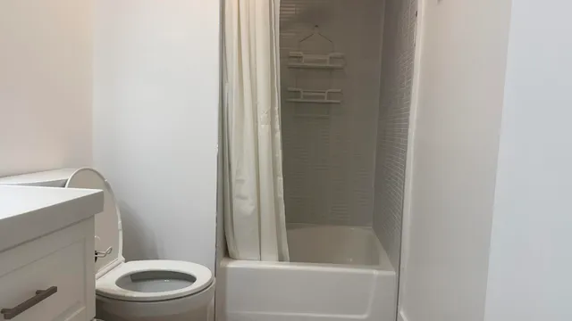 a white toilet and tub next to a shower