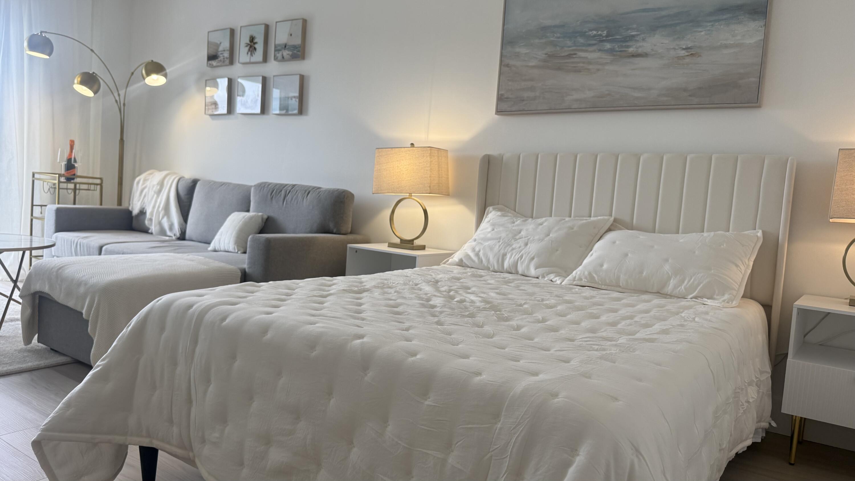 2600 North Flagler Drive, Unit 313 West Palm Beach, FL 33407 - Photo 7 of 19 a large bed sitting in a bedroom next to a lamp