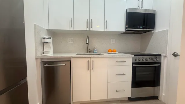 a kitchen with stainless steel appliances granite countertop a stove and a microwave