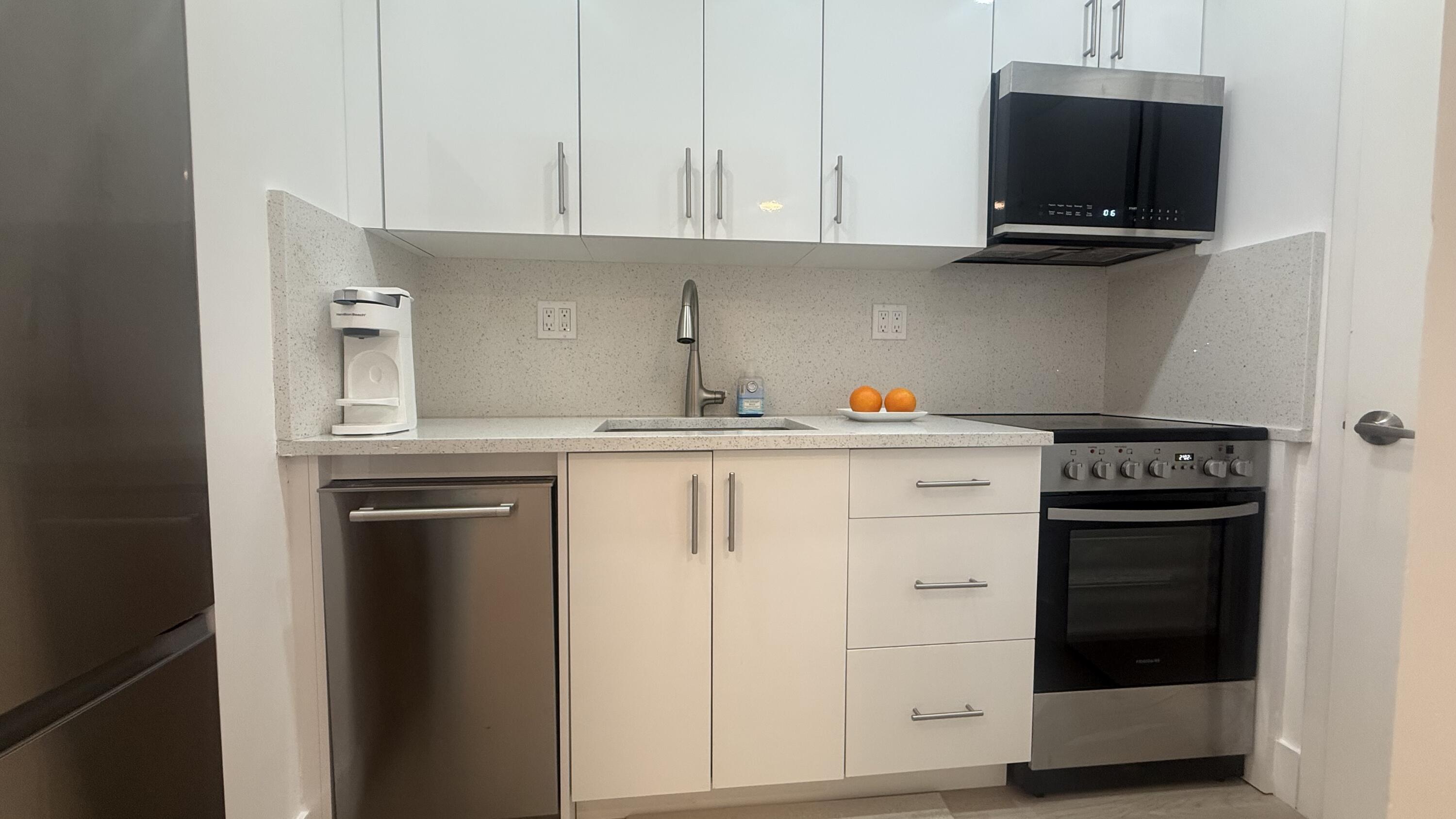 2600 North Flagler Drive, Unit 313 West Palm Beach, FL 33407 - Photo 10 of 19 a kitchen with stainless steel appliances granite countertop a stove and a microwave