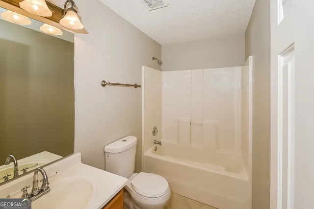 a white toilet sitting next to a bath tub