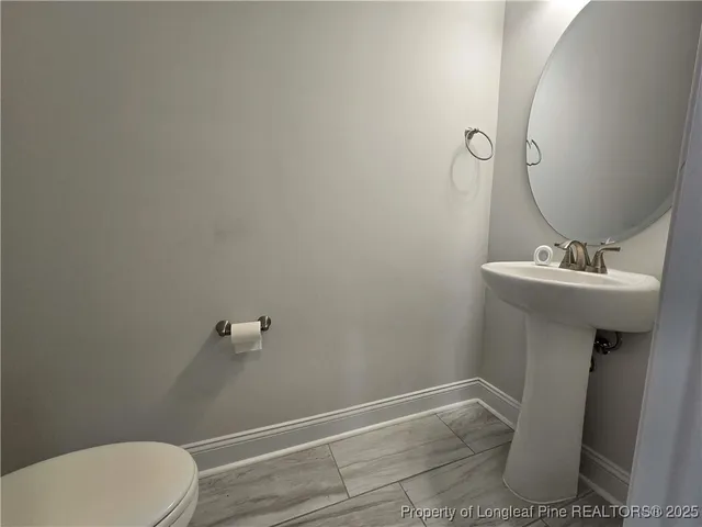 a bathroom with a sink toilet and a mirror