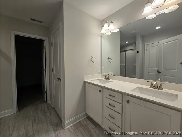 a bathroom with a double vanity sink and a mirror