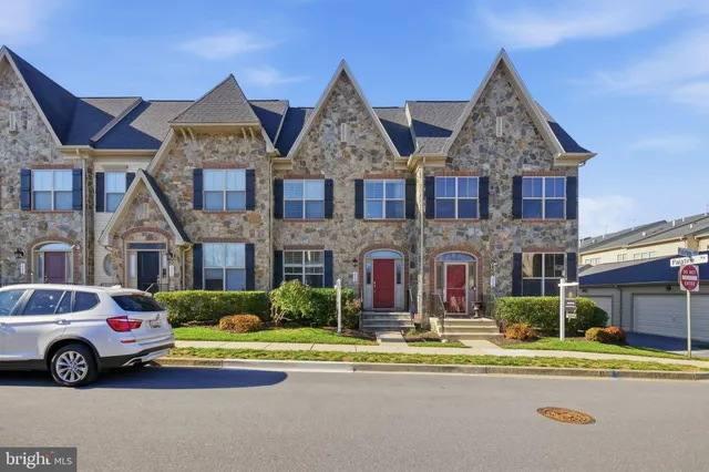 a front view of a house with a garden and parking