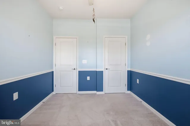 a view of an empty room with cabinet and wooden floor