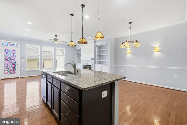 a kitchen with a sink a chandelier and wooden floor