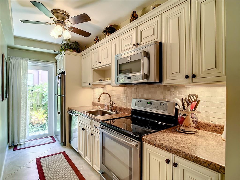 a kitchen with stainless steel appliances granite countertop a sink a stove a microwave and cabinets
