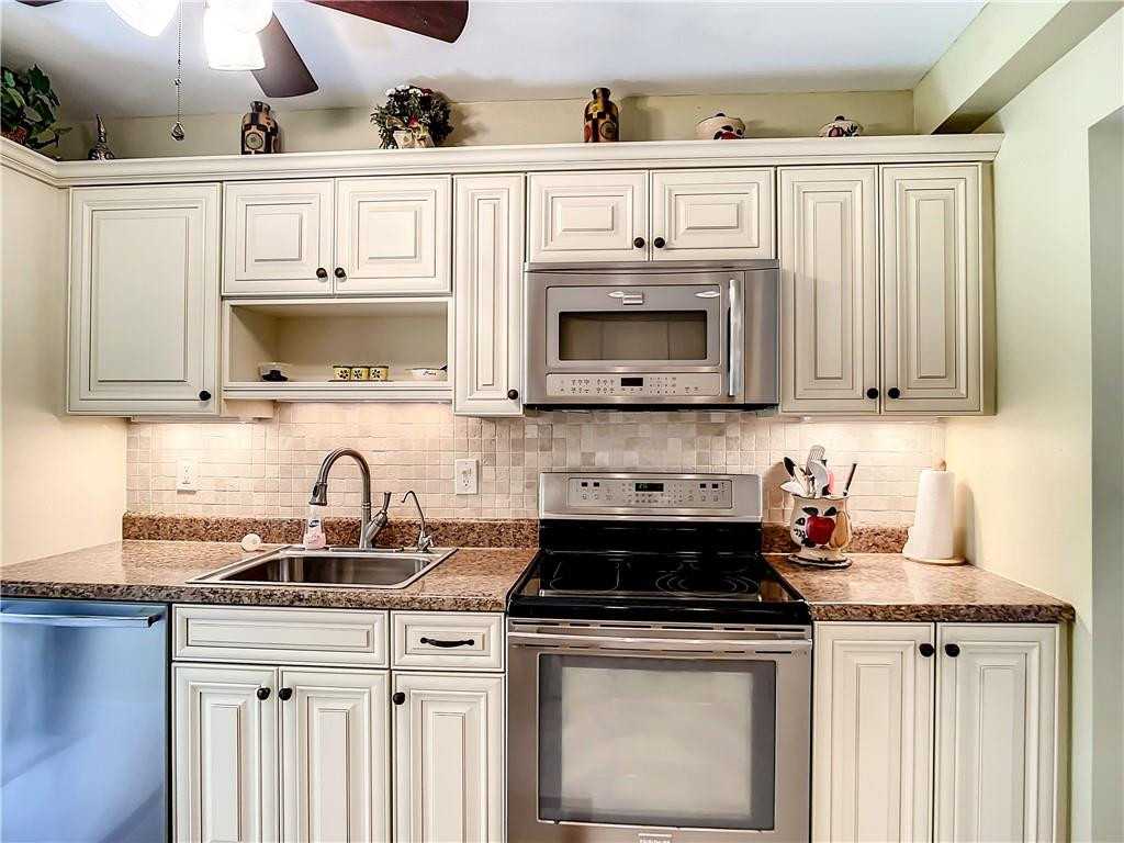 3208 Colony Club Road, Unit 2 Pompano Beach, FL 33062 - Photo 2 of 26 a kitchen with stainless steel appliances granite countertop a sink a stove and cabinets
