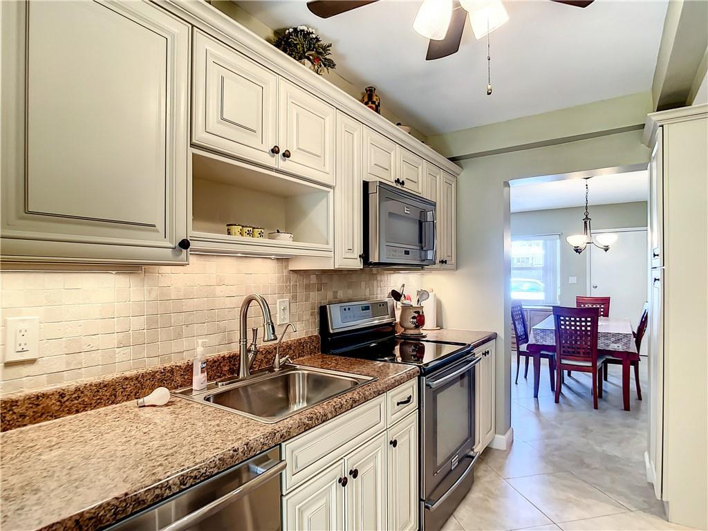 3208 Colony Club Road, Unit 2 Pompano Beach, FL 33062 - Photo 3 of 26 a kitchen with stainless steel appliances granite countertop a sink and cabinets