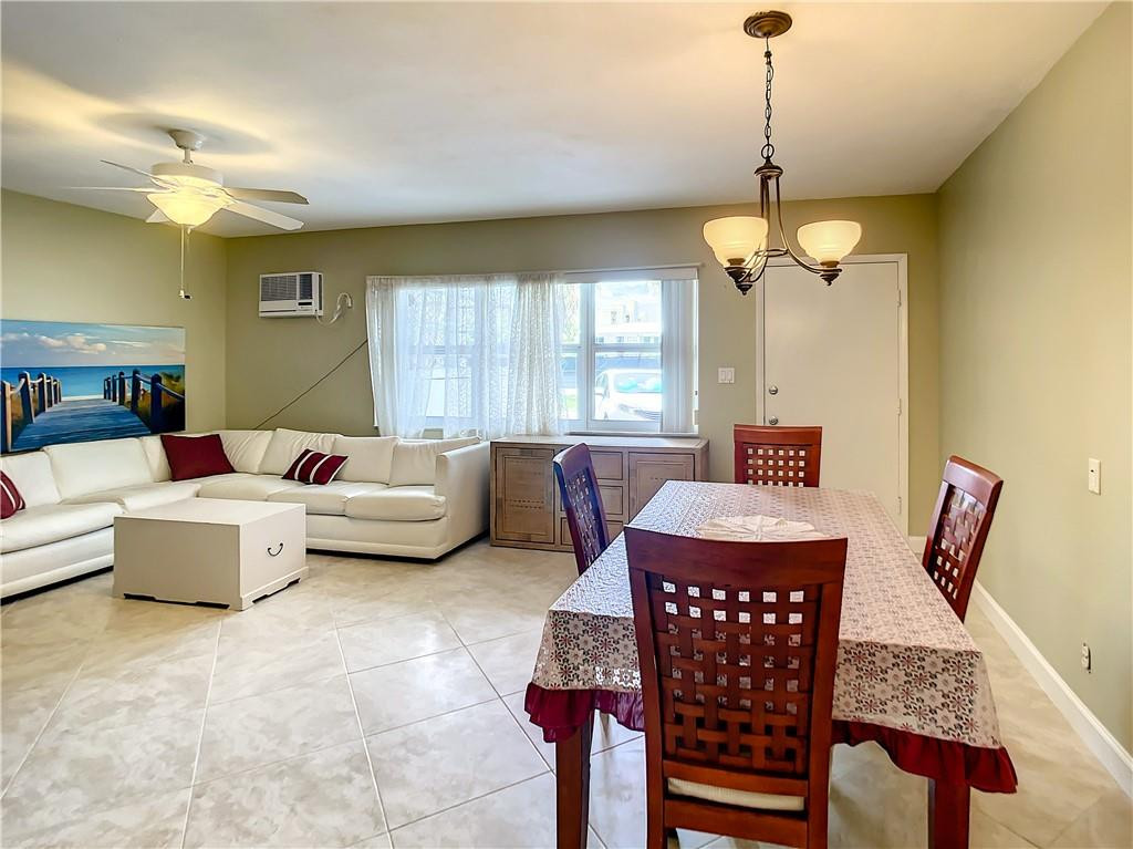 3208 Colony Club Road, Unit 2 Pompano Beach, FL 33062 - Photo 5 of 26 a living room with furniture a chandelier and a dining table