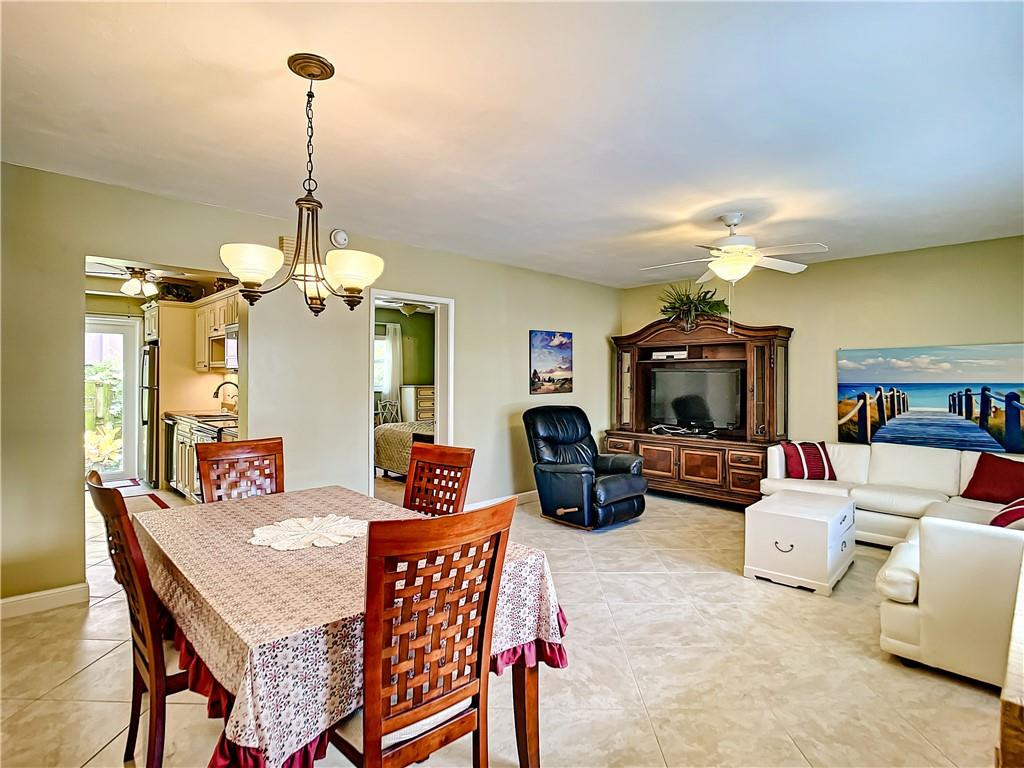 3208 Colony Club Road, Unit 2 Pompano Beach, FL 33062 - Photo 6 of 26 a living room with furniture a chandelier and a flat screen tv