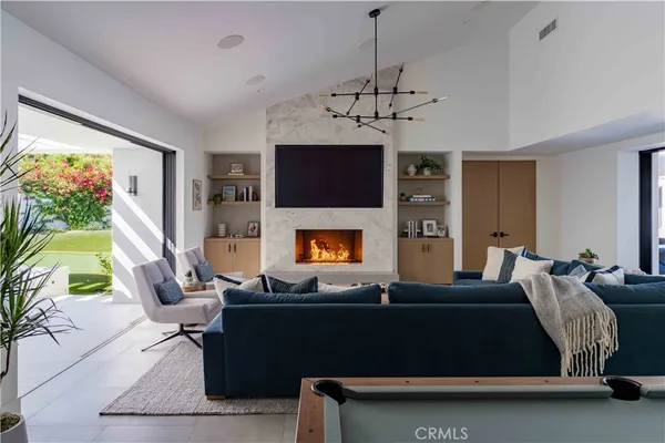 a living room with furniture a flat screen tv and a fireplace