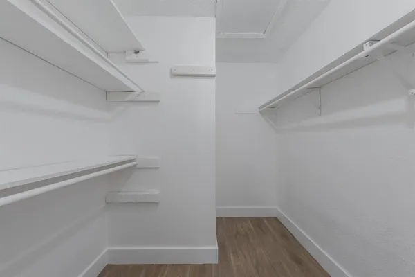a view of walk in closet with empty racks