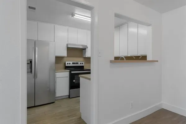 a kitchen with stainless steel appliances a refrigerator and a stove top oven