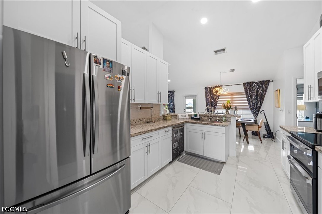 22 Nelson Road South Cape Coral, FL 33991 - Photo 16 of 43 a kitchen with sink cabinets and refrigerator