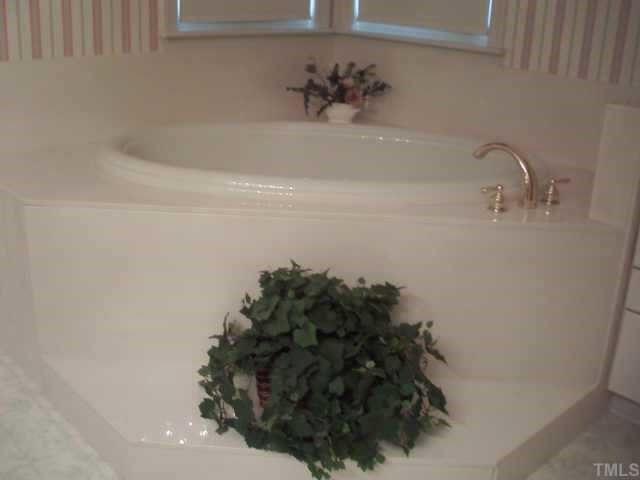 10417 Ten-Ten Road Raleigh, NC 27603 - Photo 8 of 12 a bath tub sitting in a bathroom