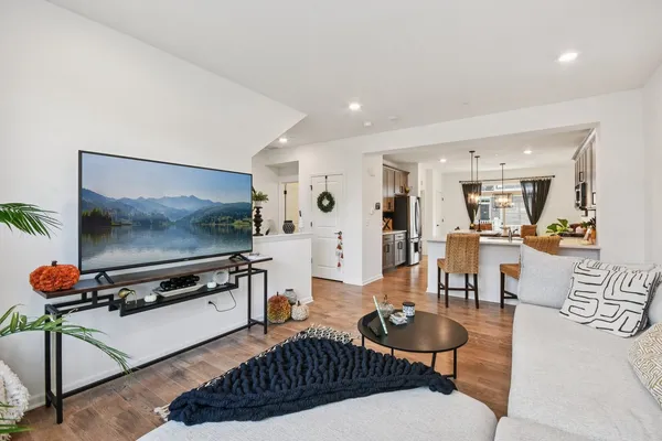 a living room with furniture a flat screen tv and kitchen view