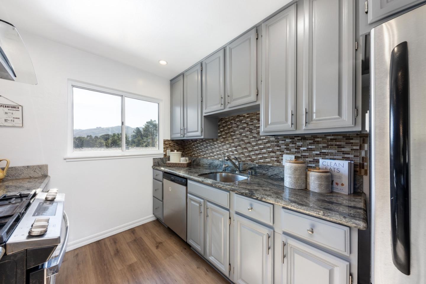 1155 Banyan Way Pacifica, CA 94044 - Photo 14 of 45 a kitchen with stainless steel appliances granite countertop a sink stove and cabinets