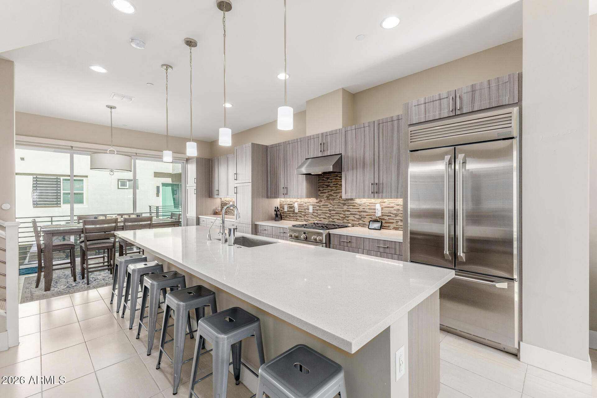 6850 East McDowell Road, Unit 71 Scottsdale, AZ 85257 - Photo 3 of 36 a kitchen with kitchen island a refrigerator a stove a dining table and chairs