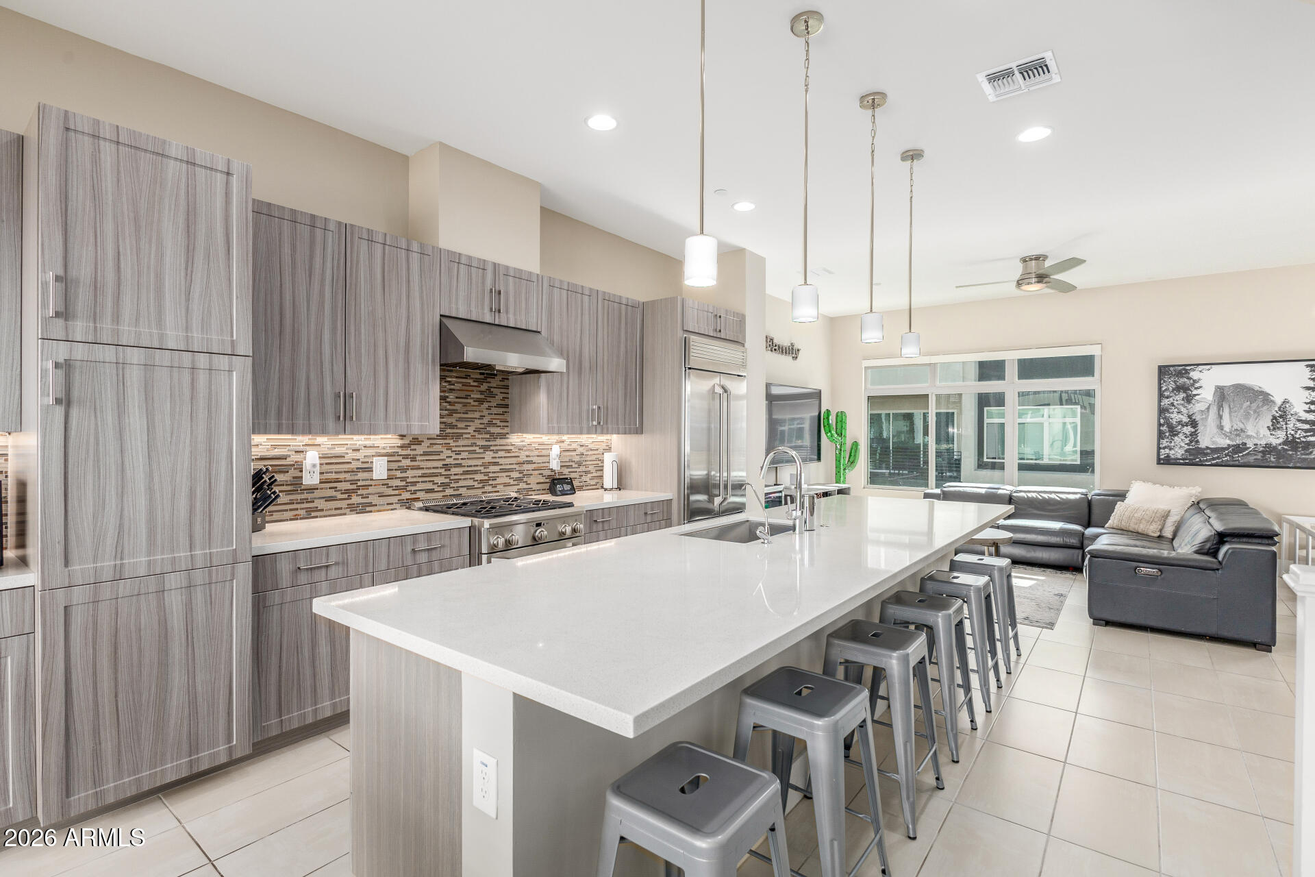 6850 East McDowell Road, Unit 71 Scottsdale, AZ 85257 - Photo 7 of 36 a kitchen with stainless steel appliances kitchen island granite countertop a stove a sink and a refrigerator with wooden floor