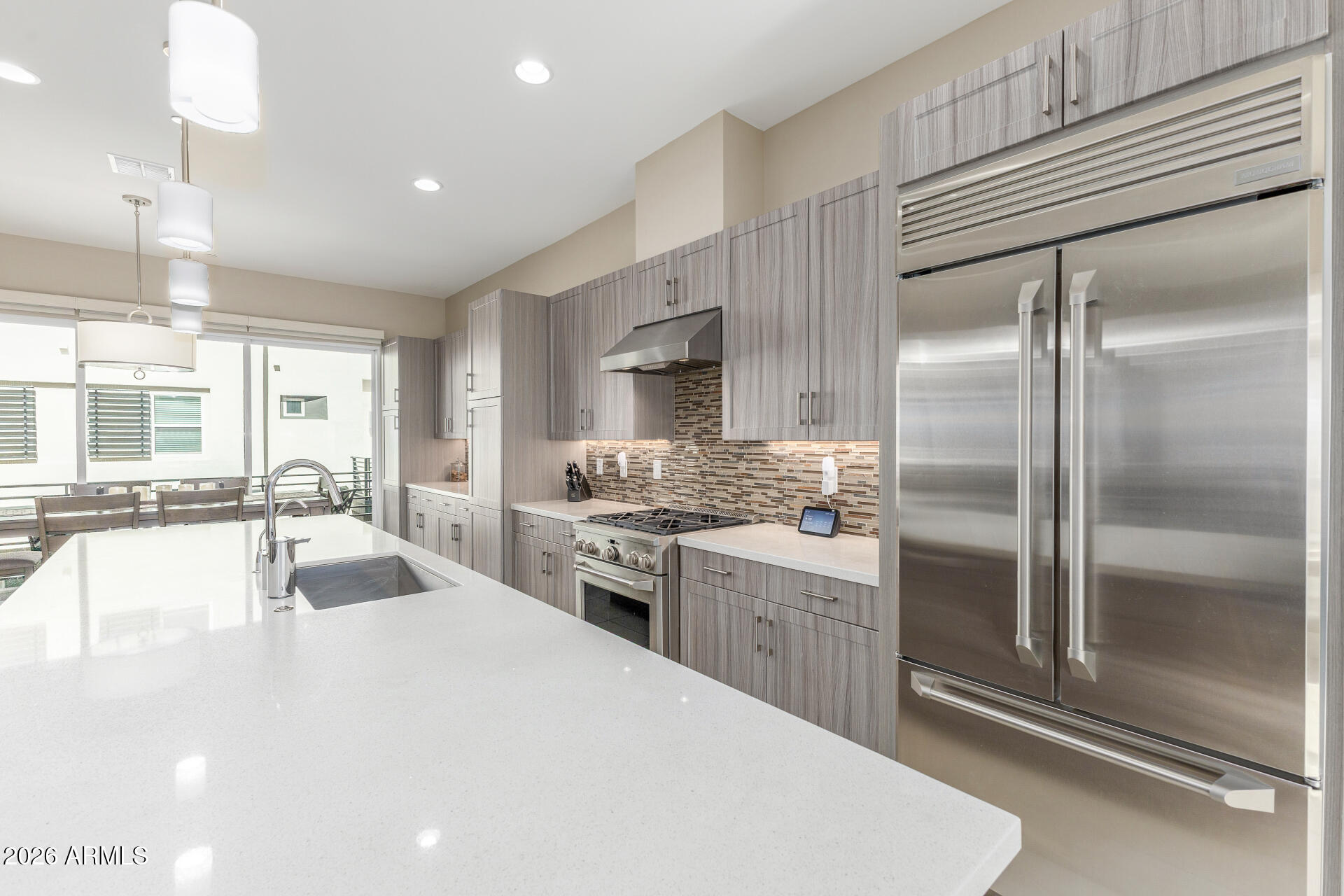 6850 East McDowell Road, Unit 71 Scottsdale, AZ 85257 - Photo 9 of 36 a large kitchen with kitchen island a large counter top space a sink stainless steel appliances and cabinets