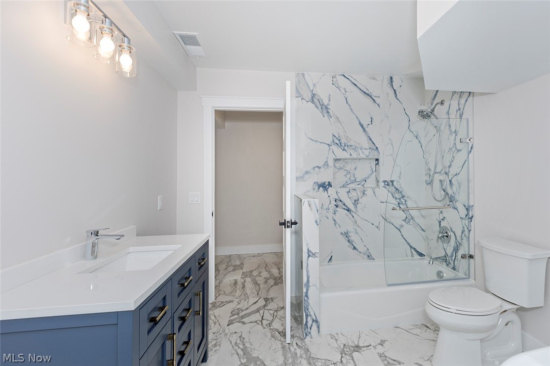 20601 Shelburne Road Shaker Heights, OH 44122 - Photo 26 of 29 First level Bathroom featuring vanity, a combined bath / shower with marble appearance, and light marble finish floors