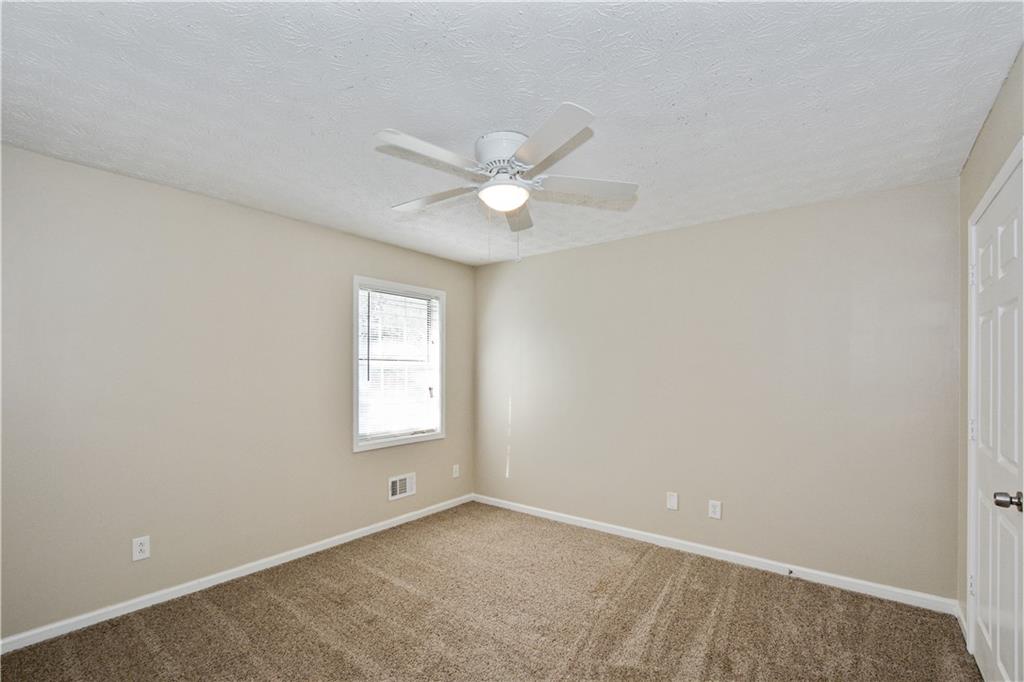 Undisclosed Address Conyers, GA 30013 - Photo 18 of 24 an empty room with a window and a fan