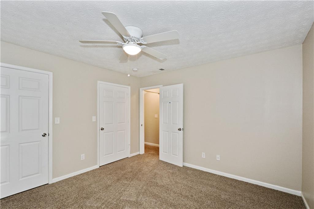 Undisclosed Address Conyers, GA 30013 - Photo 9 of 24 an empty room with a ceiling fan and a window