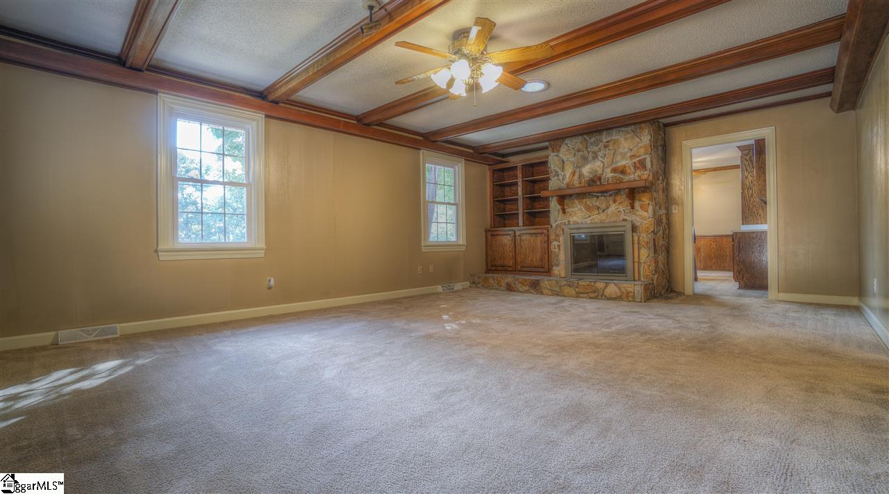 2305 East Lee Road Taylors, SC 29687 - Photo 5 of 27 Cozy living room with solid wood beams and a stone wrapped gas fireplace