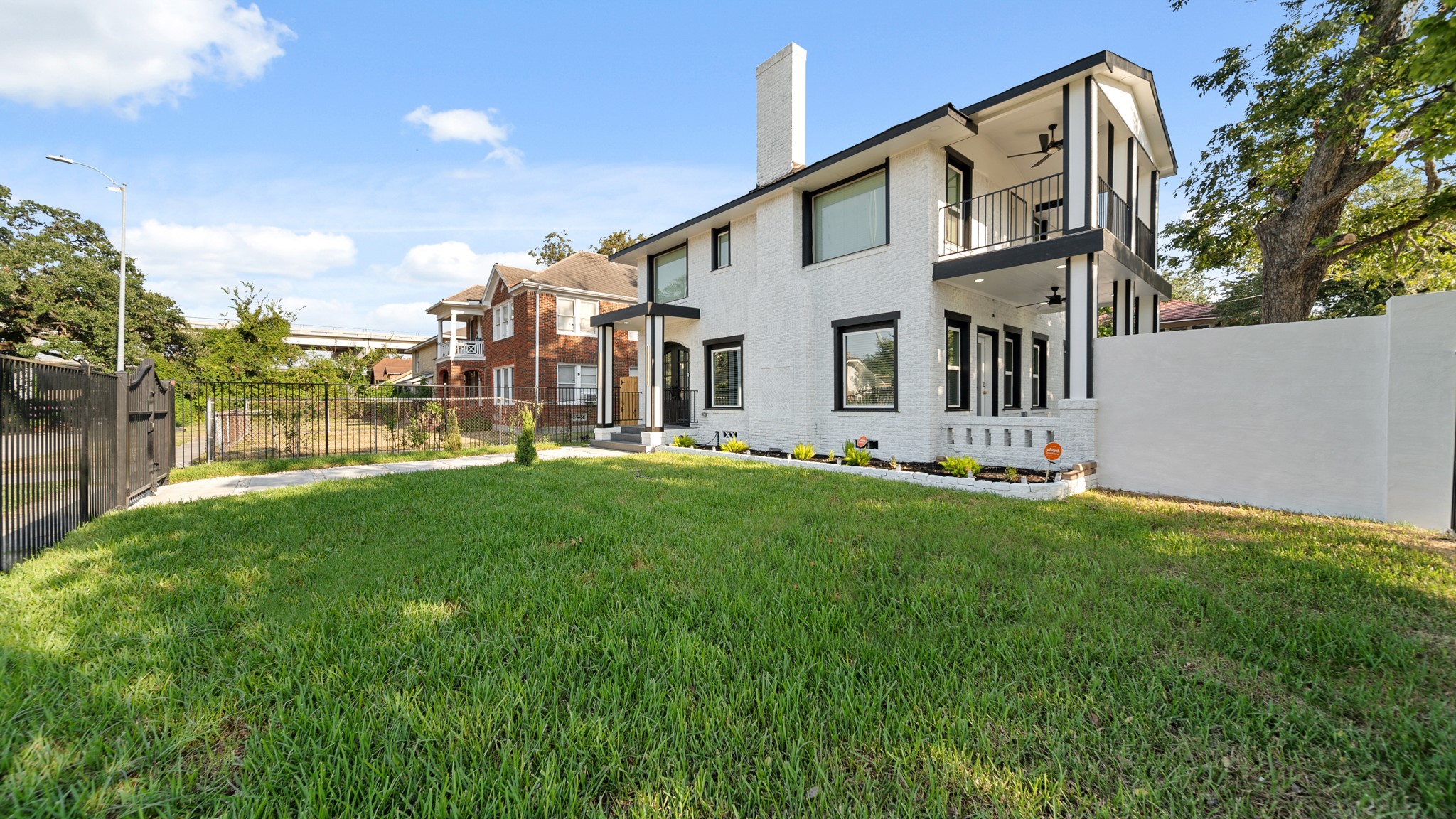 2119 Isabella Street Houston, TX 77004 - Photo 2 of 23 a view of a white house with a big yard and large tree