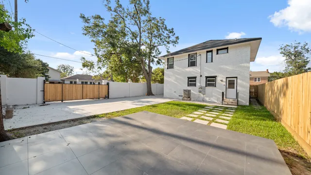 a view of an house with backyard and a tree