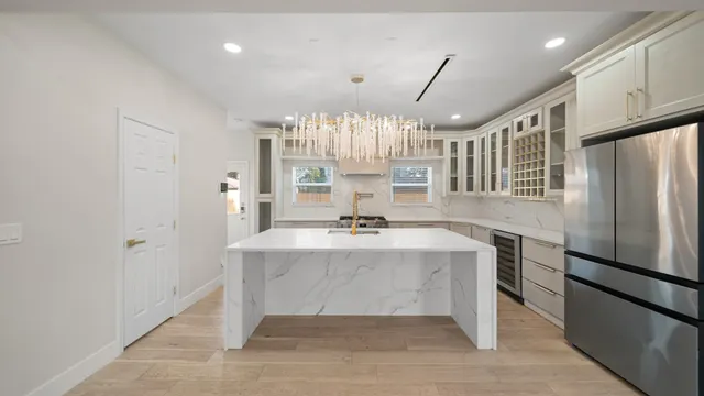 a view of kitchen with center island wooden floor and stainless steel appliances