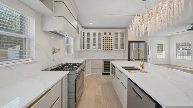 a kitchen with stainless steel appliances a sink a stove cabinets counter space and a window