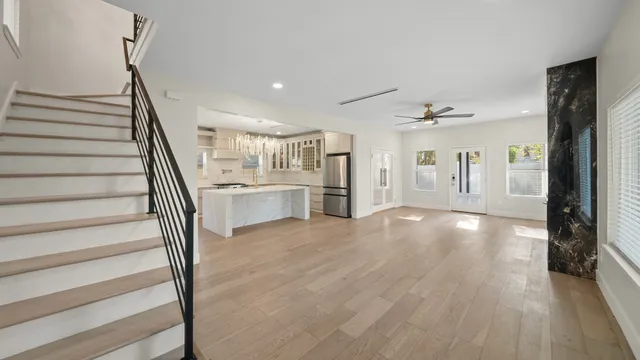a view of a hallway with wooden floor and staircase